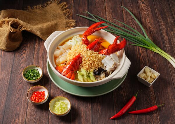 弈夢紅樓招牌「波士頓龍蝦泡飯」以整隻龍蝦搭配脆米與鮮蝦干貝高湯生滾沖淋,融合干貝、時蔬與海味食材,呈現鮮甜濃郁、層次分明的奢華口感。圖/瀚寓酒店提供