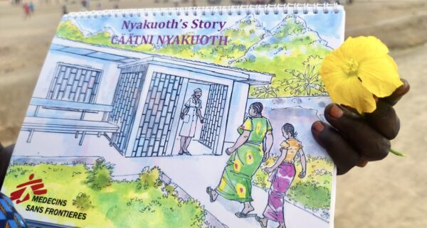 在南蘇丹班提烏（Bentiu）流離失所者營地，無國界醫生的社區核心小隊在外展活動中使用小黃花翻頁書進行教育，致力提升民眾對性暴力的防範意識。照片攝於2022年3月7日。© Florentina Popa/MSF