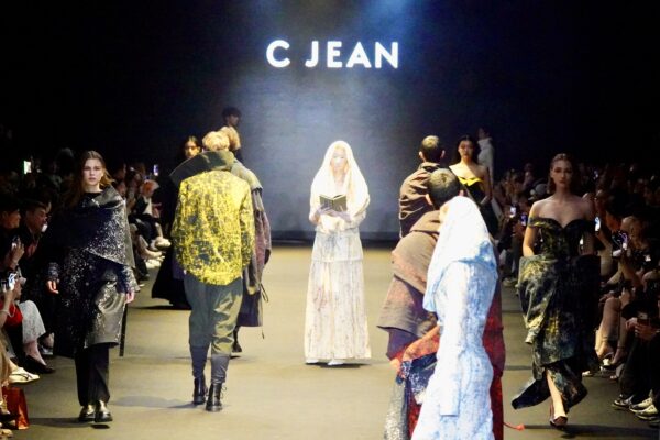 C JEAN 26AW 臺北時裝週開幕秀現場，模特兒於伸展台演繹「SA TA NA MA」生命循環主題，以服裝、光影與儀式感構築一場融合哲學與時尚的沉浸式展演。圖/主辦單位