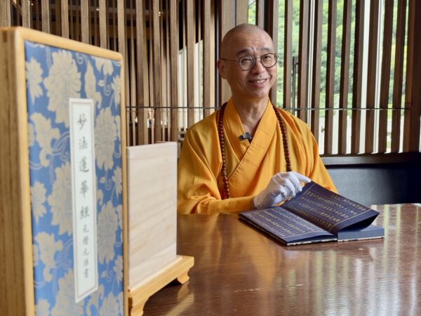 法藏大和尚向記者介紹,由僧伽林文化出版有限公司發行的《妙法蓮華經》泥金復刻古美術,鎮宅與收藏價值。圖/楠西萬佛寺