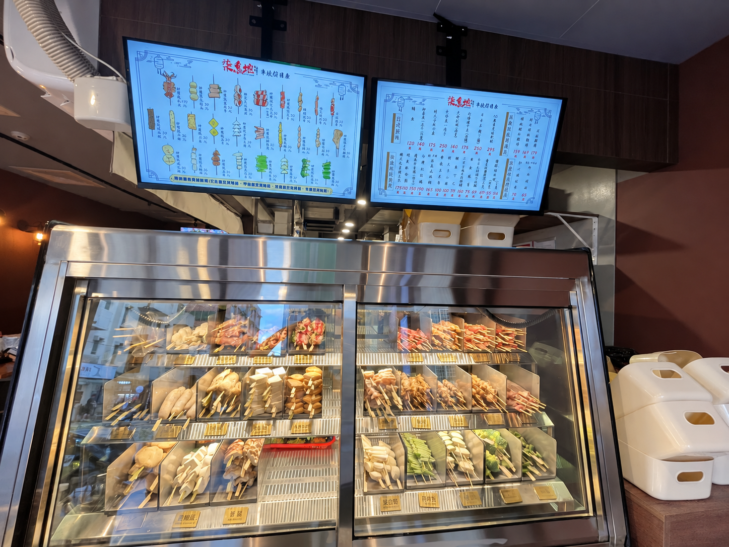 柒息地串燒居酒屋林口長庚店展示櫃陳列多款肉類、蔬菜與其他串燒食材,供顧客挑選。(圖/朱立君攝)