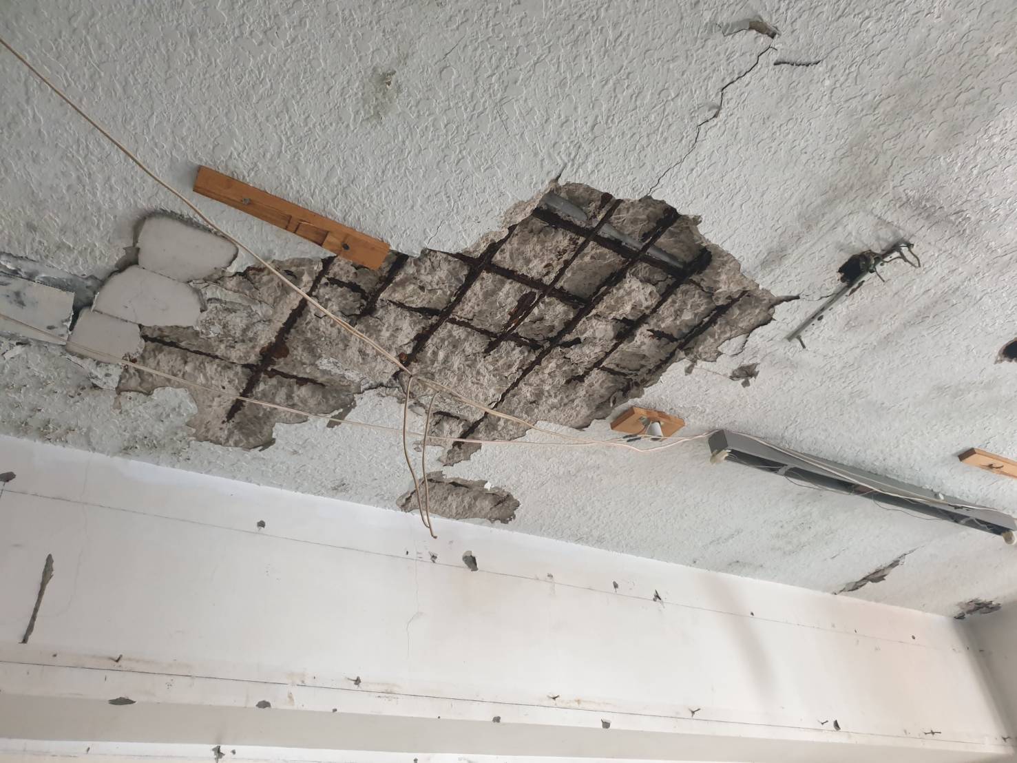 建築物天花板混凝土剝落、鋼筋外露且可見鏽蝕。專家提醒，屋主應請專業技師檢查，釐清損壞原因及結構狀況，避免只做表面修補。（圖／建築安全履歷協會提供）