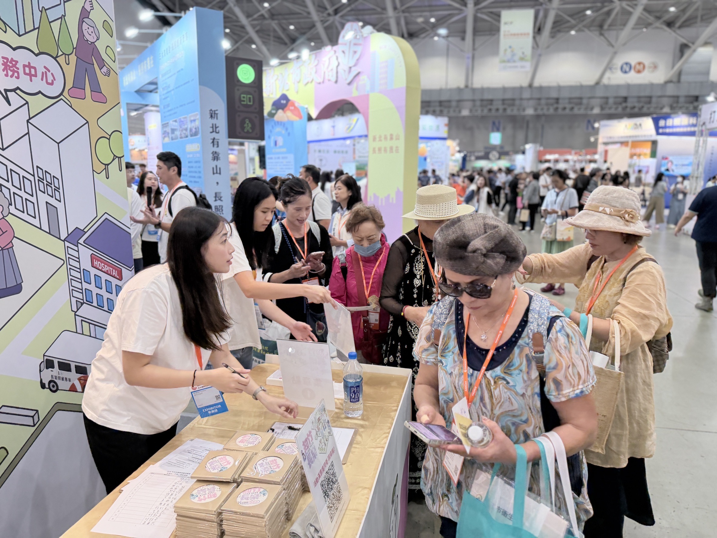 新竹市「知竹長樂」展區吸引民眾駐足，工作人員介紹長照資源與互動活動，讓參觀者認識在地照顧服務。（圖／新竹市政府提供）