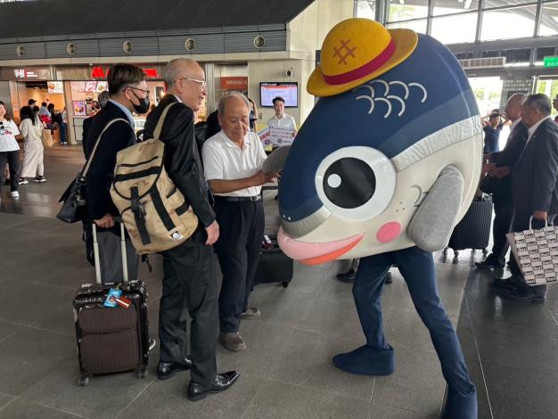 臺南觀光吉祥物「魚頭君」現身臺南火車站與旅客互動，為百年車站增添歡樂氣氛，邀請民眾國慶連假走訪府城、留下鐵道旅行回憶。（圖／臺南市政府觀光旅遊局提供）