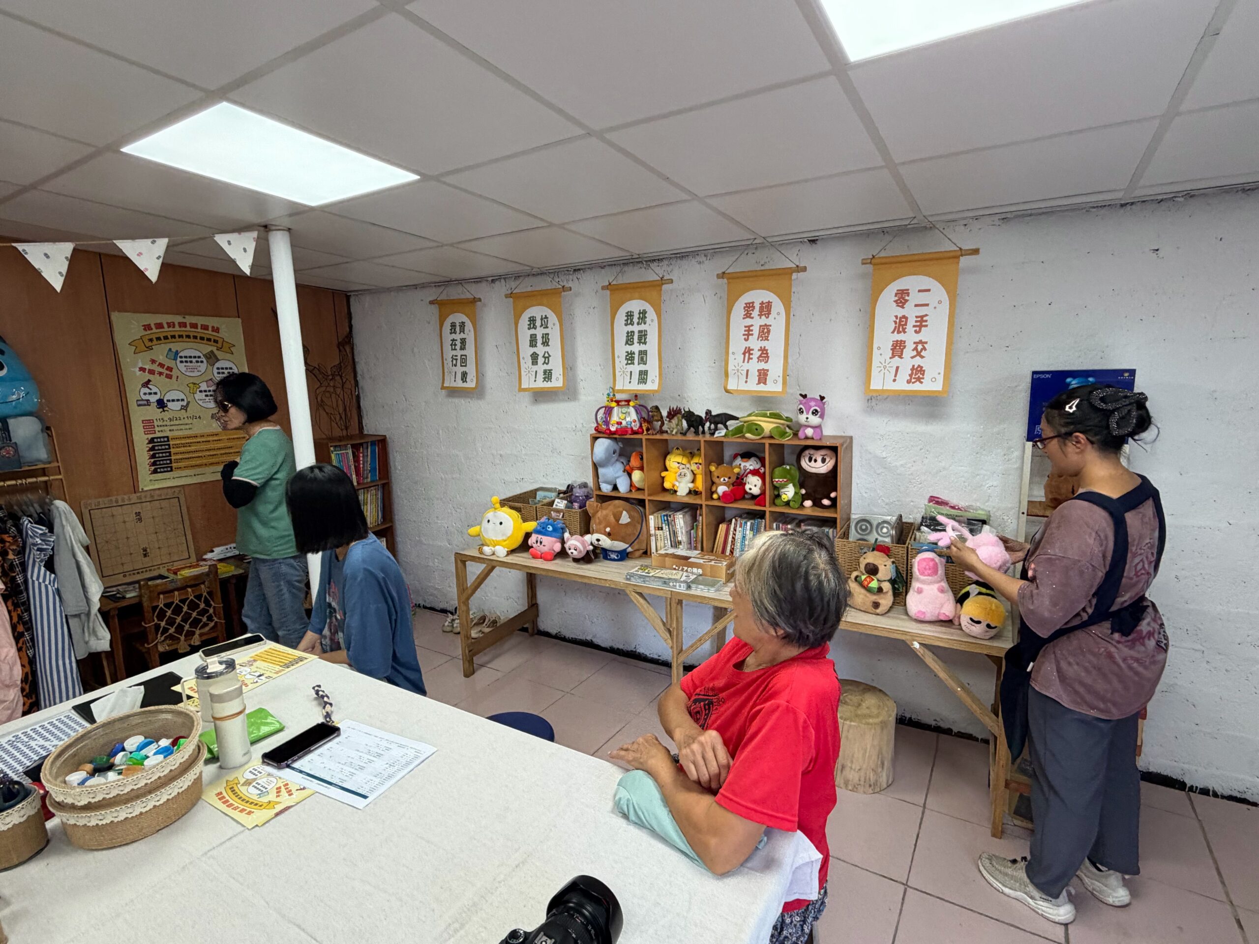 民眾走進萬榮社區「花蓮好物循環站」，瀏覽現場展示的二手衣物、書籍與玩偶，透過分享與再利用，讓閒置好物延續使用價值。（圖／花蓮縣環境保護局提供）