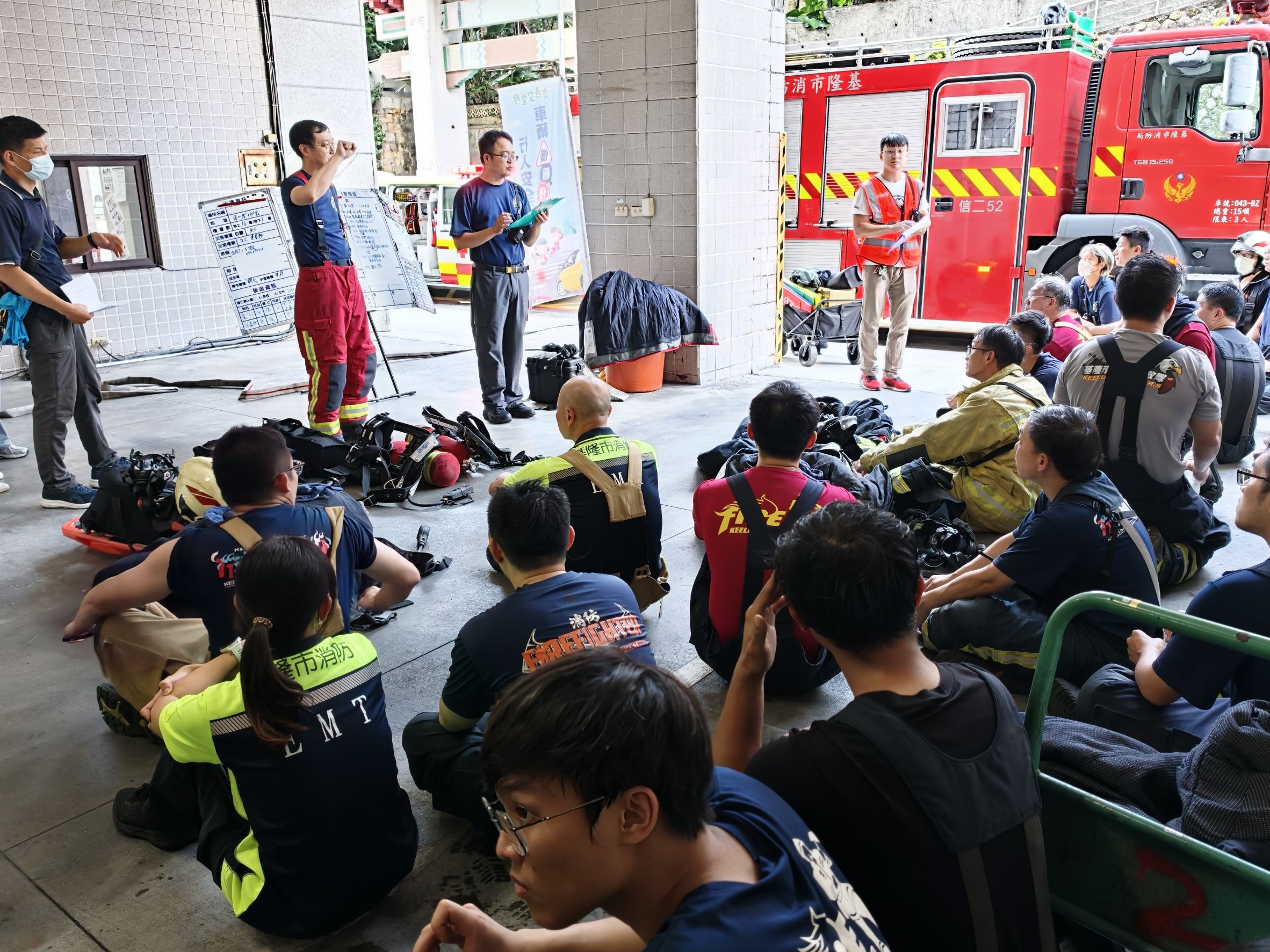 基隆市消防局參演人員進行地下停車場火警演練任務檢討,針對搜救、滅火及安全管制作業交流,精進救災協同能力。(基隆市消防局提供)