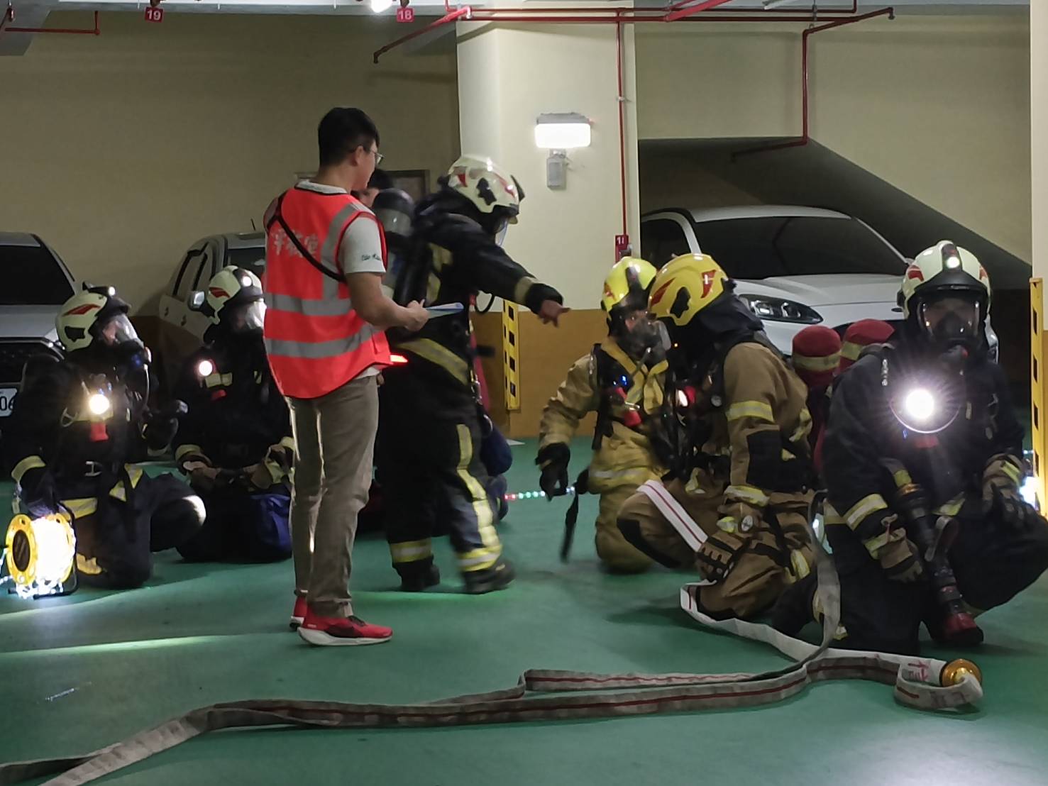 基隆市消防人員穿戴完整防護裝備集結,準備進入地下停車場執行模擬火警搶救任務,強化地下空間救災應變能力。(基隆市消防局提供)