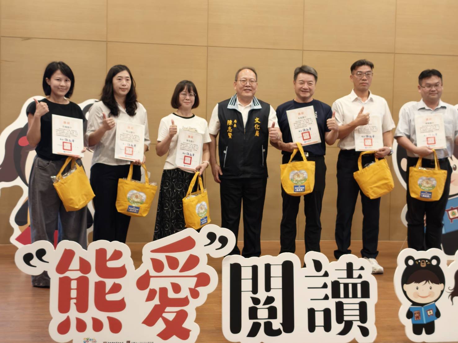 南投縣文化局長陳志賢（中）與「熊愛閱讀」獲獎代表合影，肯定學校及公共圖書館推動閱讀、鼓勵創作的努力。（圖／南投縣政府提供）