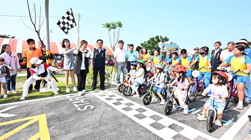 大城追風公園啟用，孩童戴上安全帽、騎乘滑步車於起跑線前蓄勢待發，彰化縣長王惠美與現場貴賓共同揮旗，展現園區交通體驗特色。（圖／彰化縣政府提供）