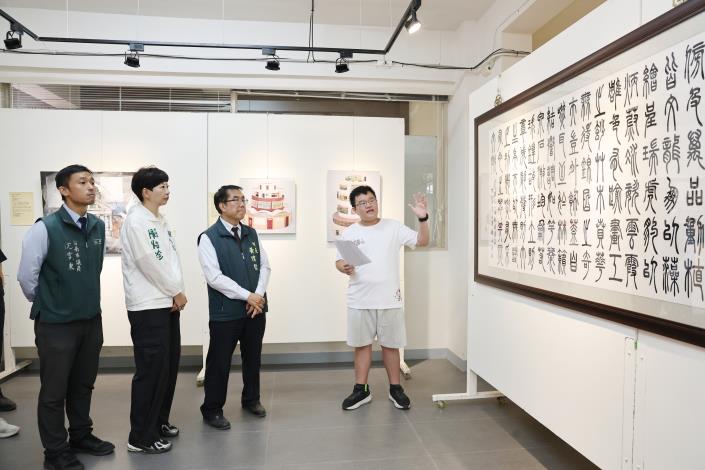 台南市長黃偉哲於民德國中58週年校慶期間參觀藝文展覽，聆聽現場導覽，欣賞書法及繪畫作品。（圖／台南市政府提供）