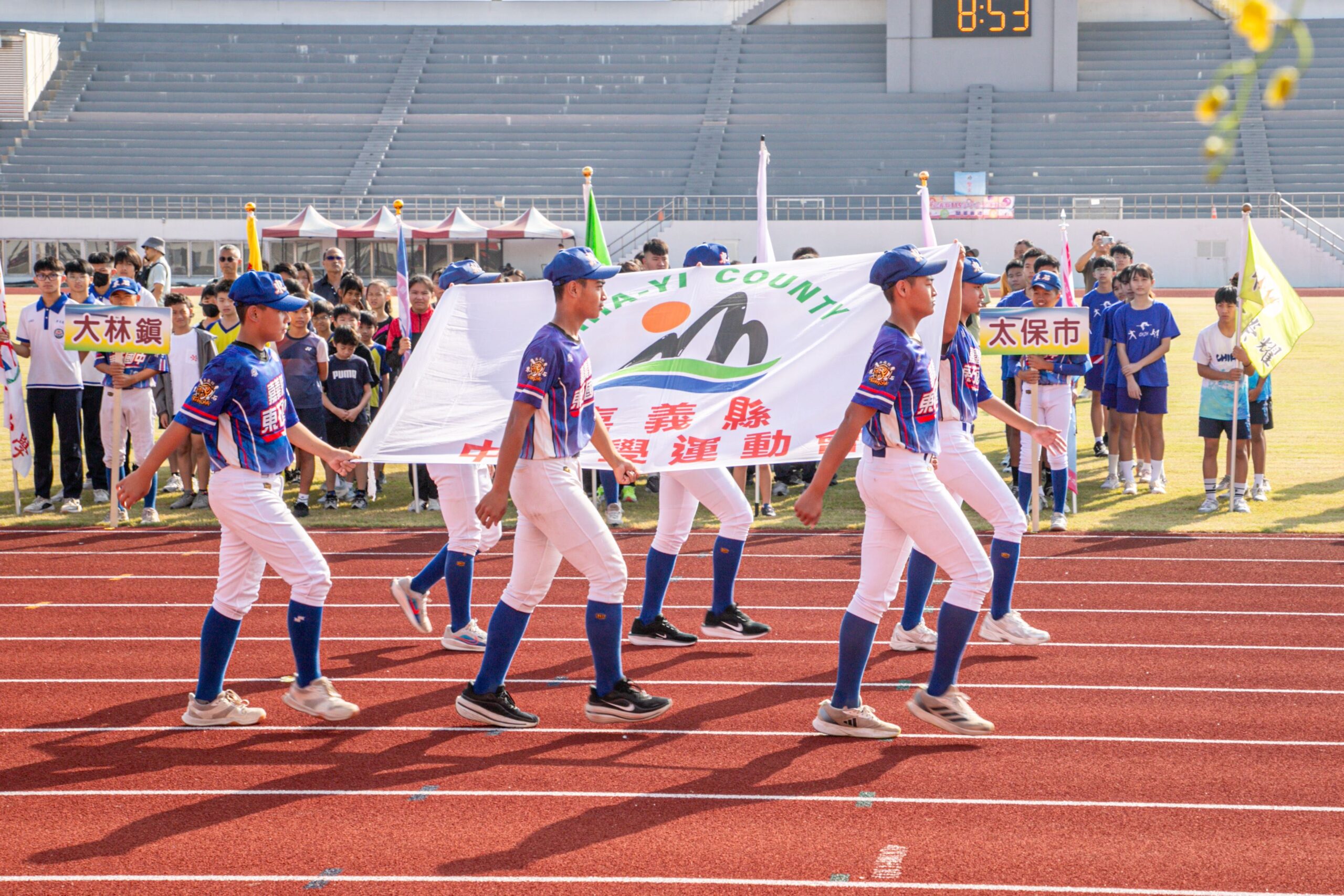 嘉義縣115年中小學聯合運動會開幕，學生高舉大會旗幟進場，展現青春活力與運動精神。（圖／嘉義縣政府提供）