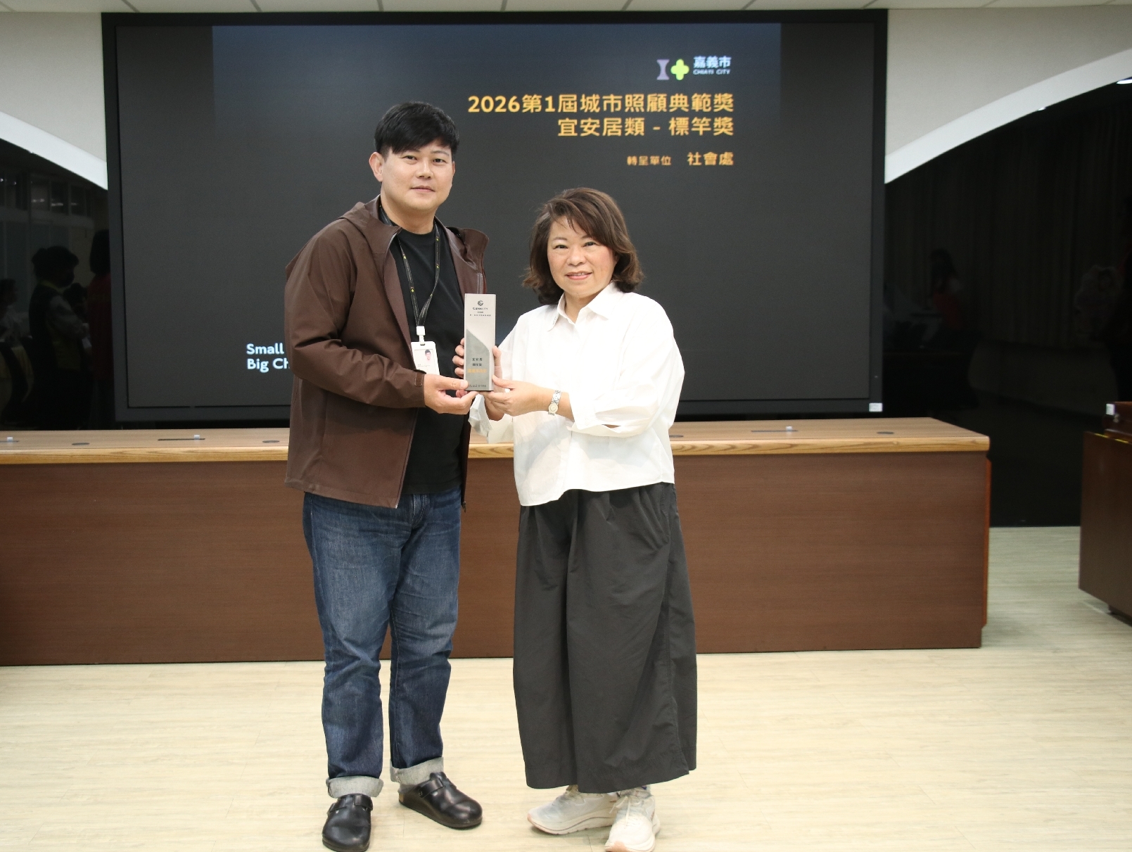 嘉義市「橘世代－銀采綻放活躍飛揚」方案榮獲城市照顧典範獎「宜安居類－標竿獎」，社會處長李思賢於市務會議將獎座轉呈市長黃敏惠，分享高齡服務成果。（圖／嘉義市政府提供）